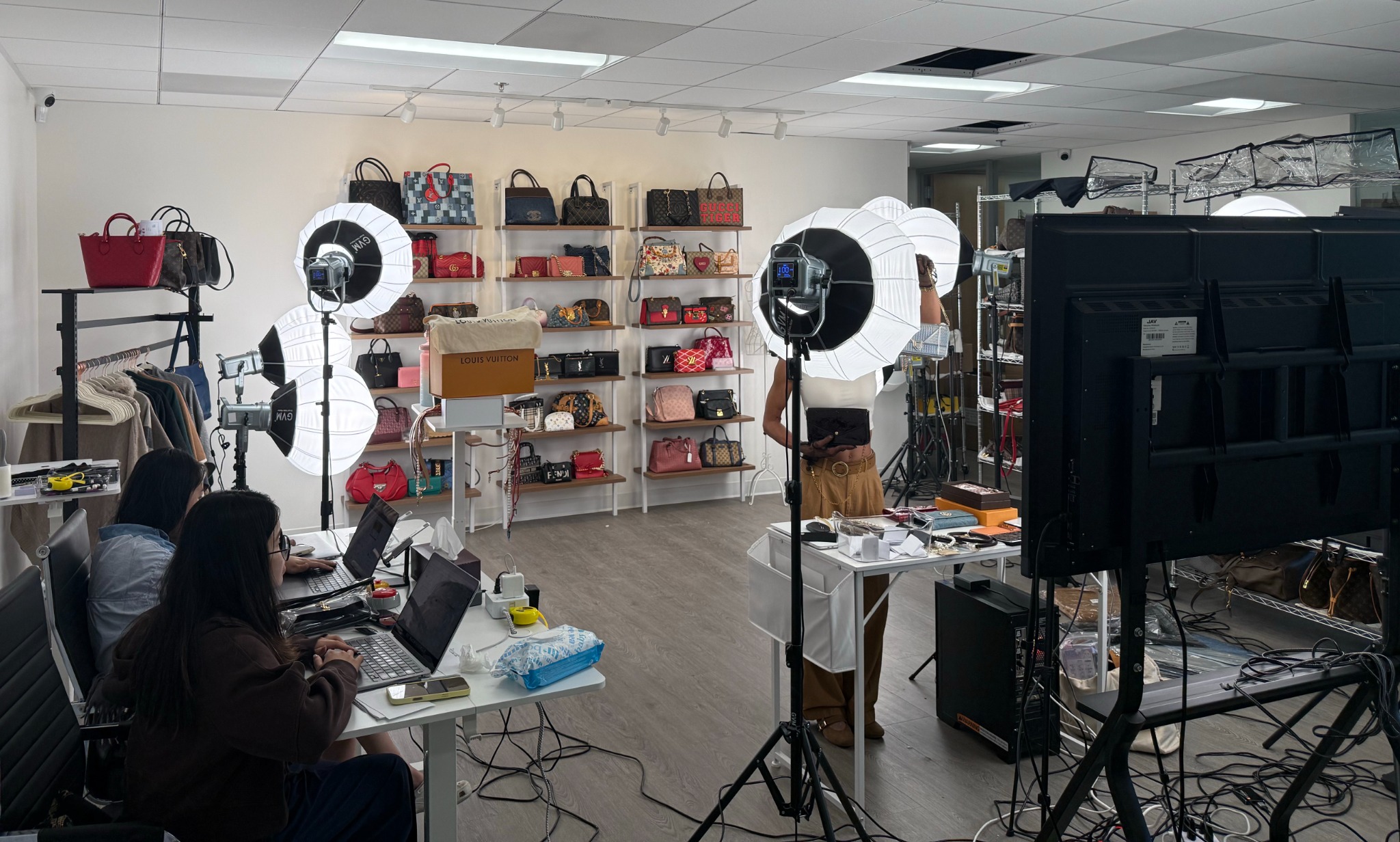 Luxury handbag livestream production studio with lighting, product displays and an operations team